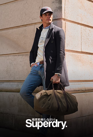 Modelo de Superdry posando con una maleta de mano